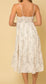 White sleeveless smocked tiered midi dress with black floral design